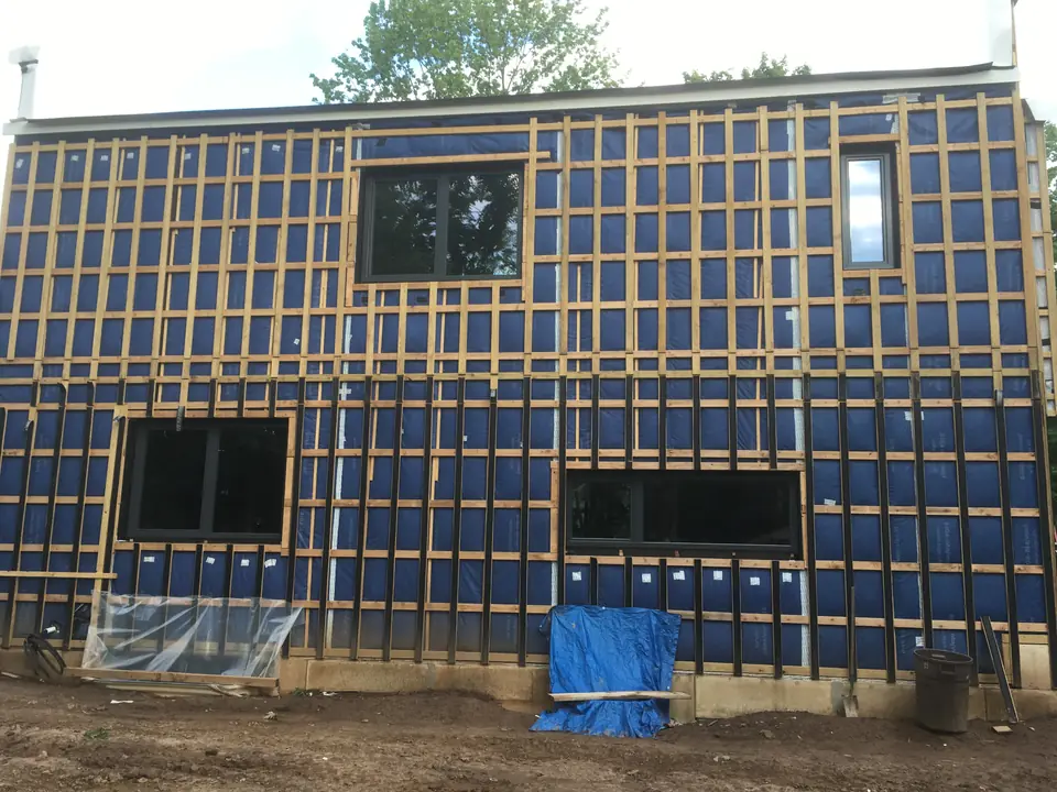 The exterior view of the installed windows with sealing tapes around them. They will be double-insulated with foam blocks from inside and ou